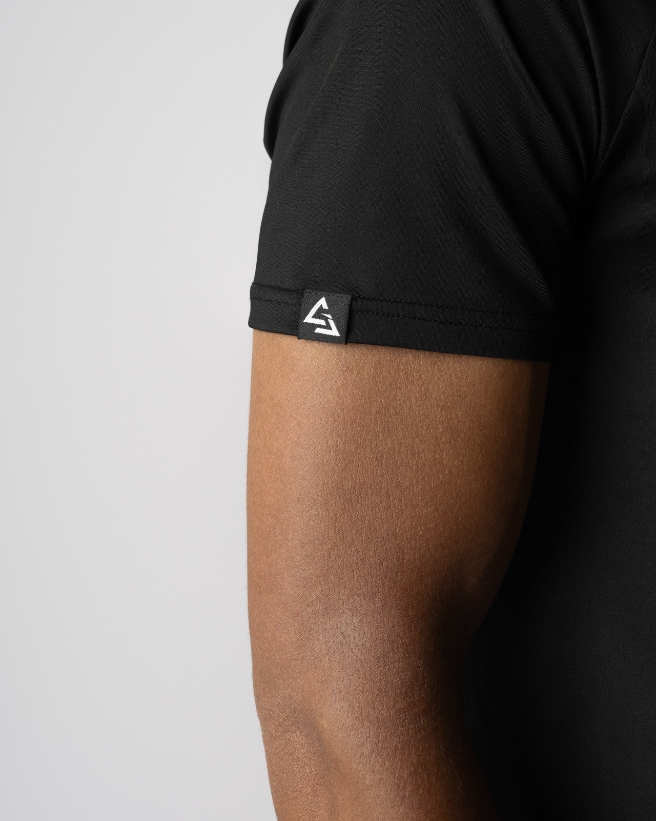 Detail van het armlabel op de Manga Trainings T-shirt van Gym Junkie, subtiele branding voor sporters die kiezen voor kwaliteit en karakter in hun gymwear