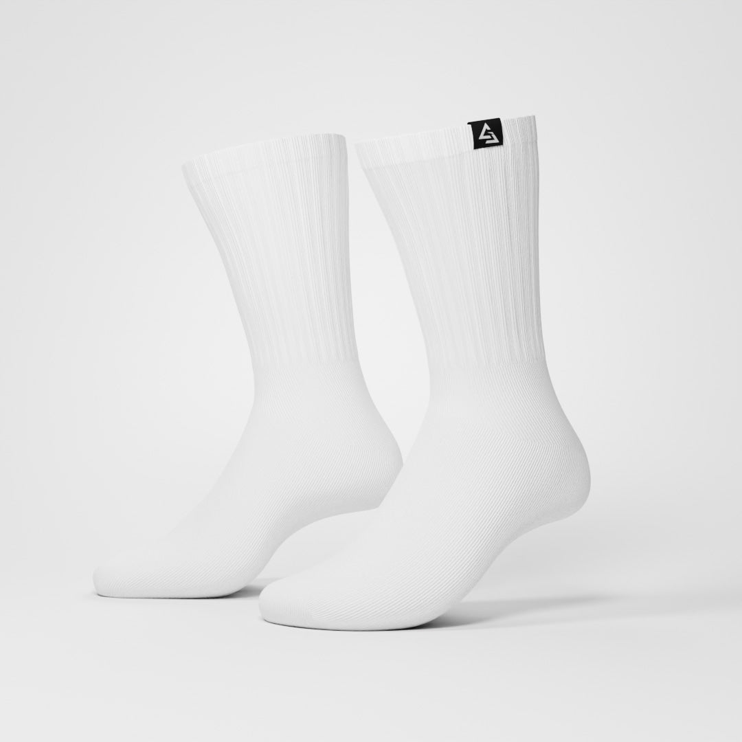 Twee witte sokken met Gym Junkie-logo op label, gepresenteerd op een lichtgrijze achtergrond