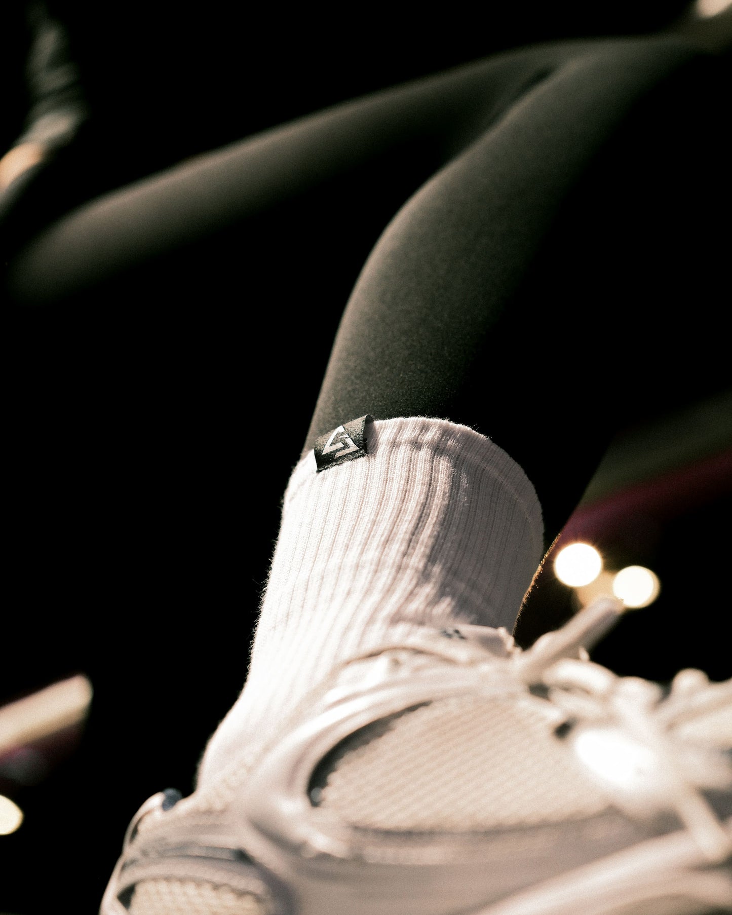 Close-up lifestyle foto van witte GJA crew sokken – comfortabele en stijlvolle sportsokken van Gym Junkie - Dames en heren sportsokken