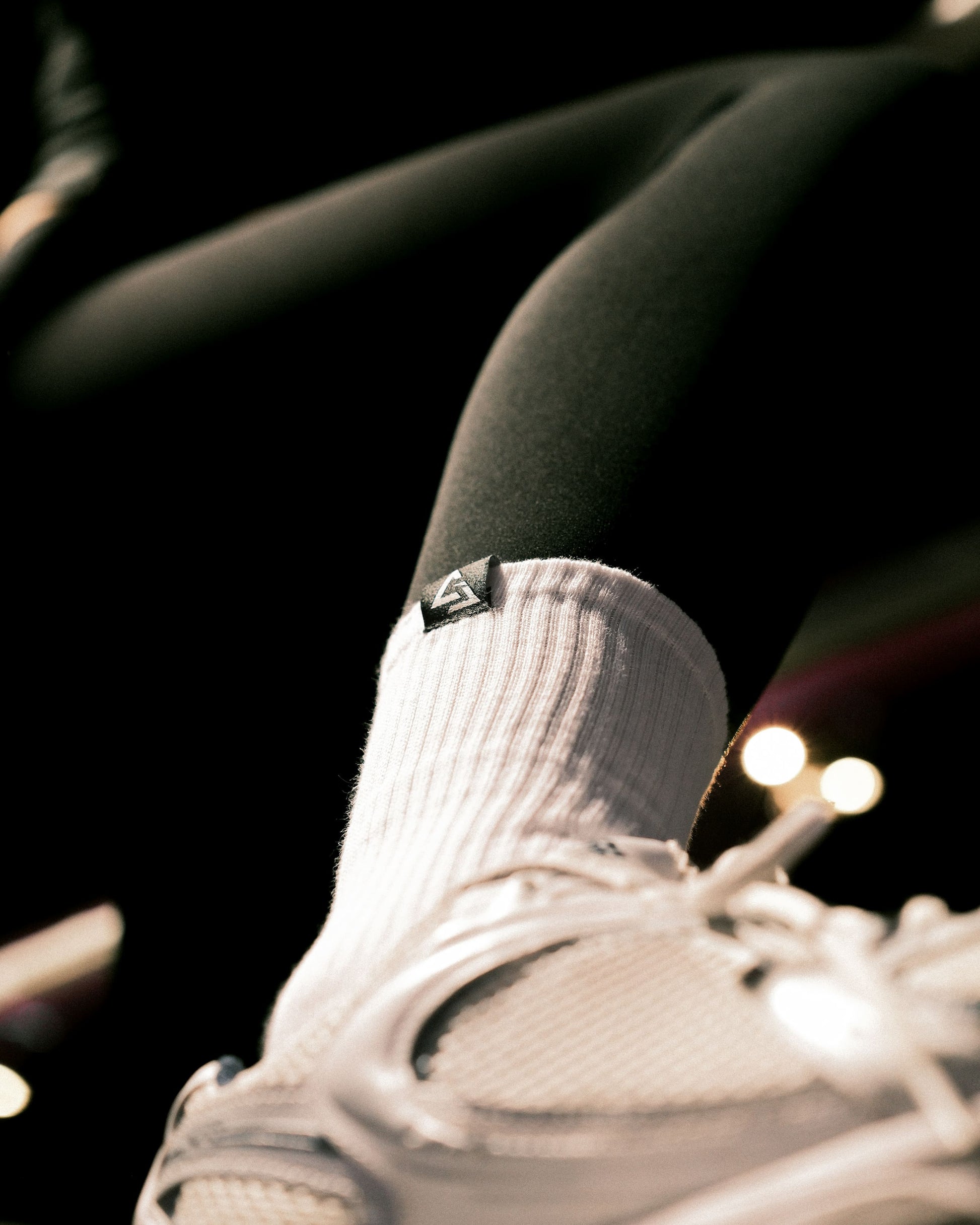 Close-up lifestyle foto van witte GJA crew sokken – comfortabele en stijlvolle sportsokken van Gym Junkie - Dames en heren sportsokken