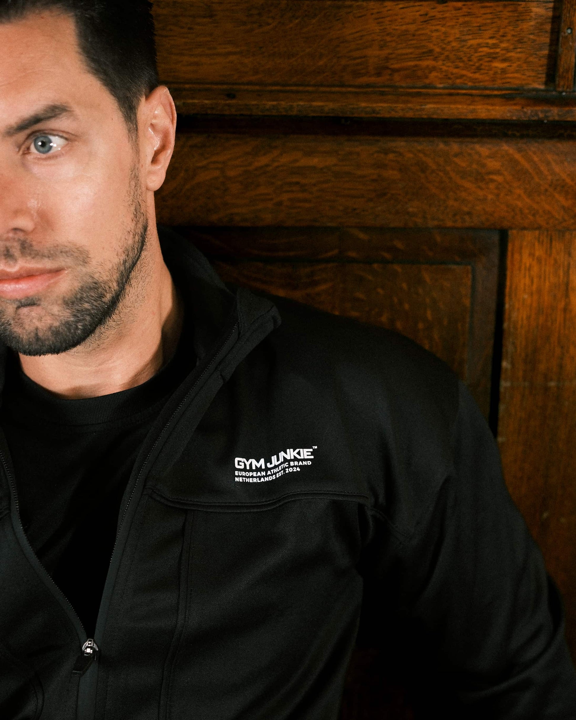 Close-up van rits en Gym Junkie logo op trainingsjas voor heren, gedragen in de sportschool, detail van sportieve streetwear stijl - Heren sportjassen