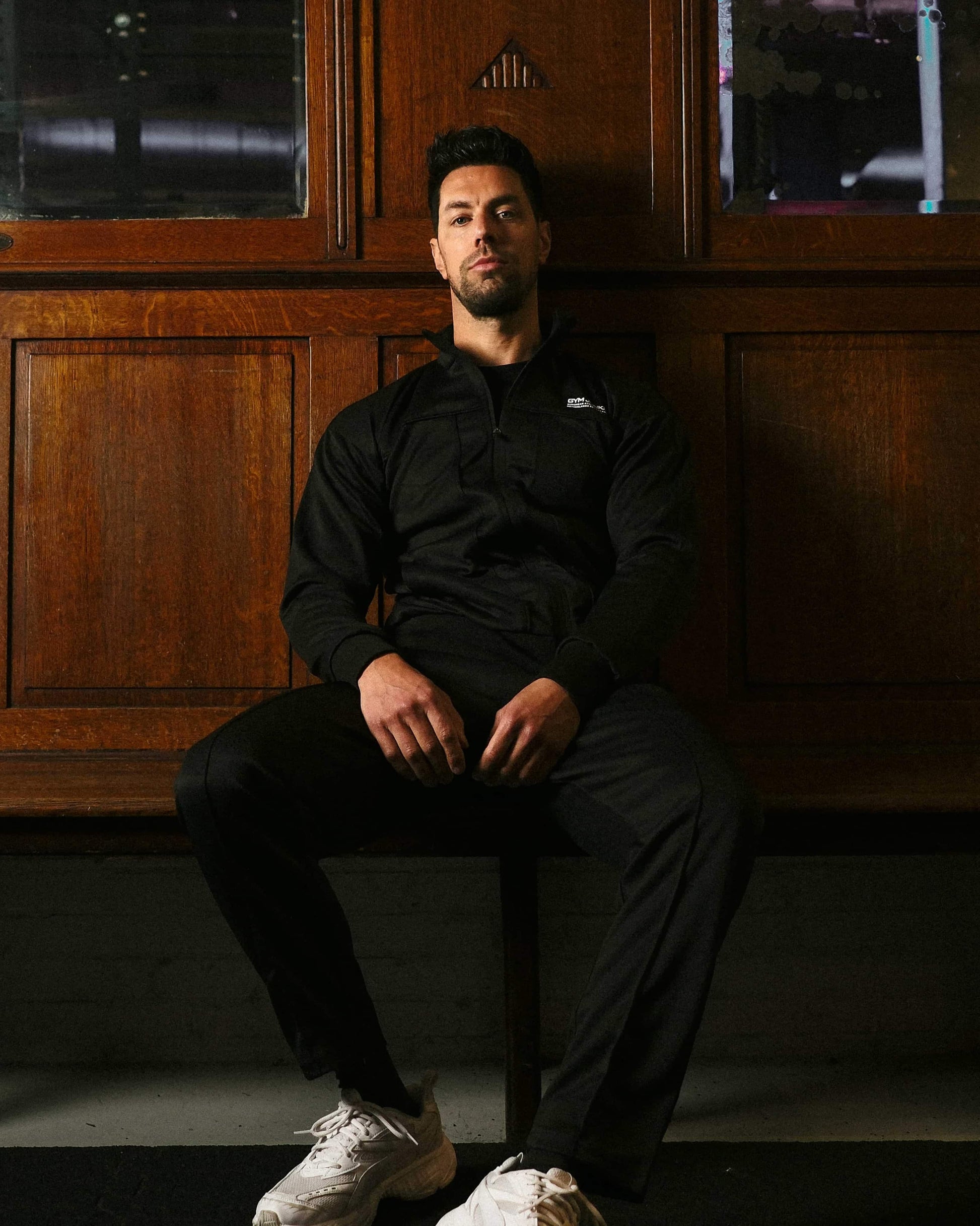 Banner mannen collectie met man zittend in GJA Classic trainingspak – comfortabele en stijlvolle sportoutfit -Gym Junkie, sportkleding voor heren