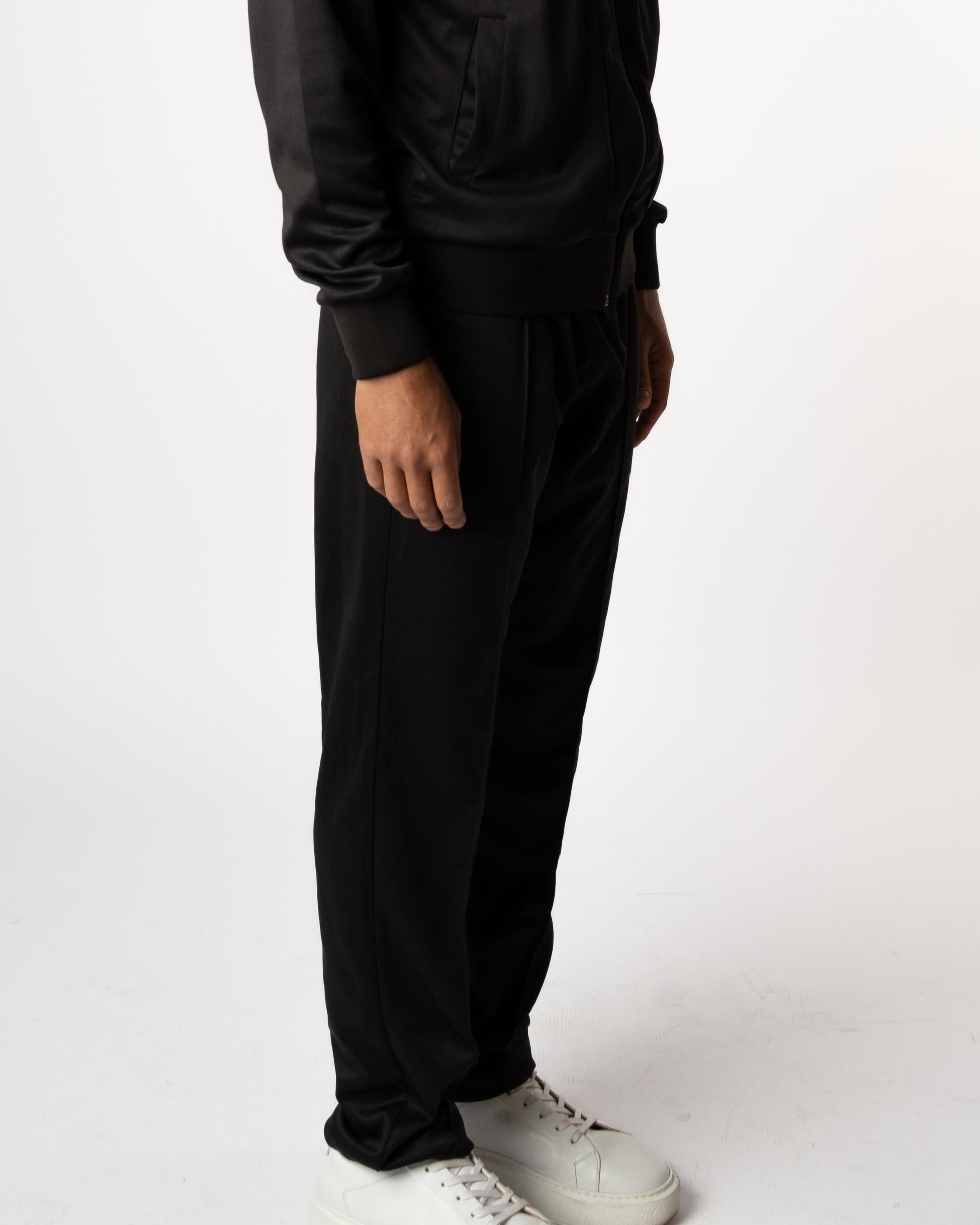 Zijaanzicht van model in zwarte Gym Junkie trainingsbroek voor heren, sportieve en stijlvolle look voor jongvolwassenen in Nederland. - Heren sportkleding