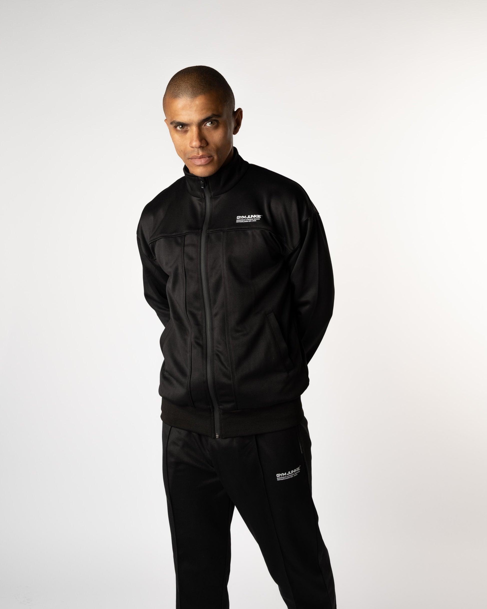 Man solo in Gym Junkie trainingspak, moderne sportoutfit voor heren van 16–30 jaar in Nederland, comfortabele en krachtige uitstraling. Sportbroeken voor heren.