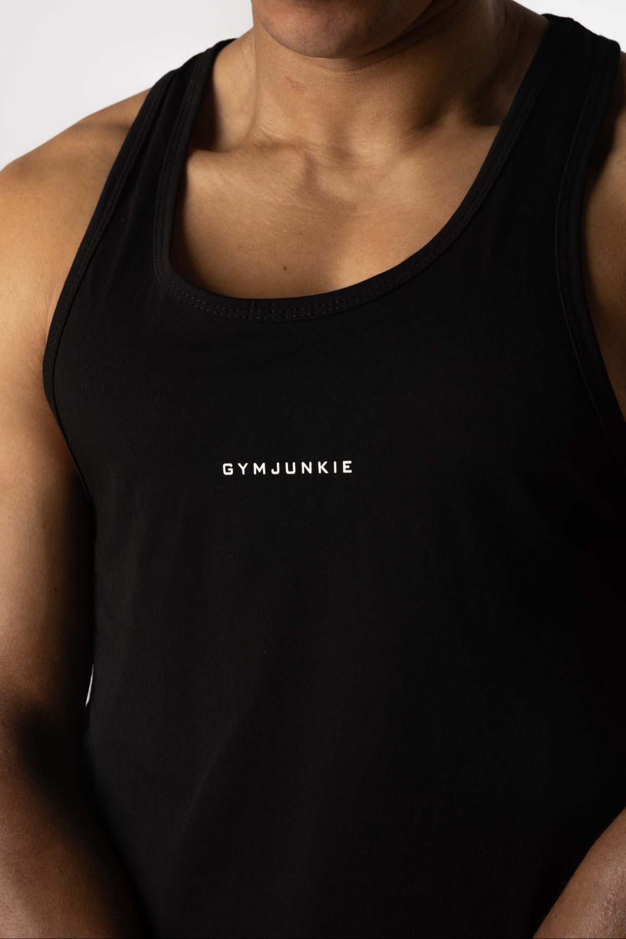 Close-up van de voorkant van de zwarte Magna Stringer, onderdeel van de Gym Junkie collectie voor sportkleding - Heren Trainings Tanktops