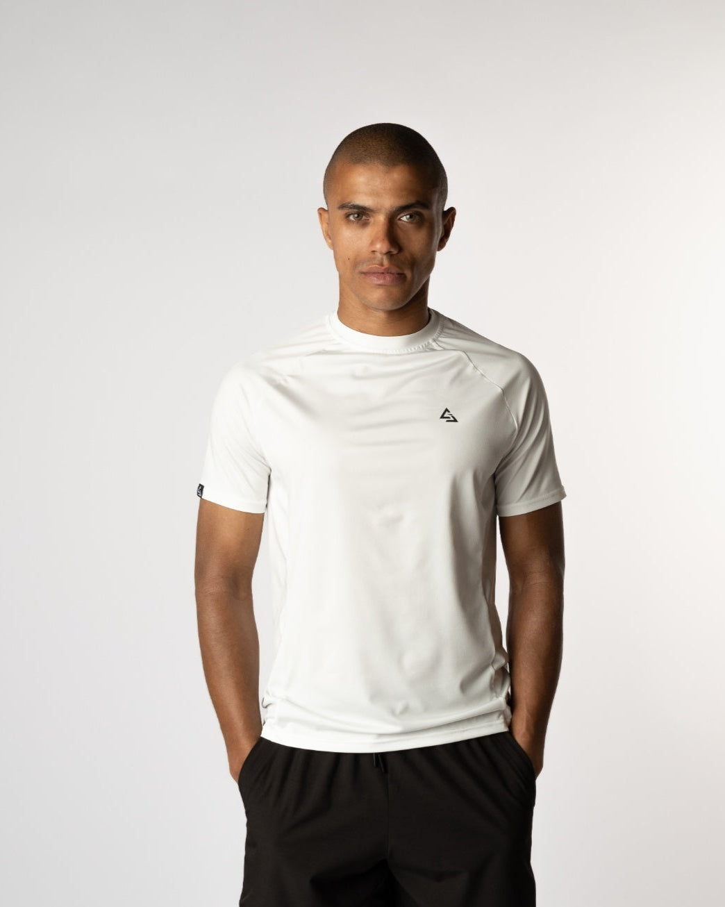 Vooraanzicht van een mannelijke model in de Magna Witte Trainings T-shirt en onyx gym shorts van Gym Junkie, ideaal voor actieve mannen - Sportkleding voor mannen