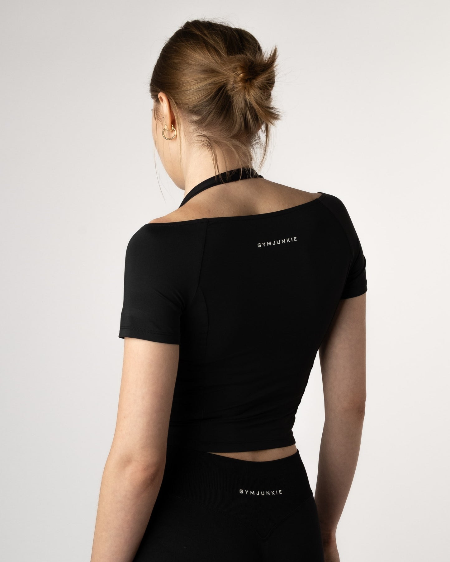 Detail close-up van de achterkant van de Nora Boothals Crop Top gecombineerd met zwarte Liberty Leggings van Gym Junkie.