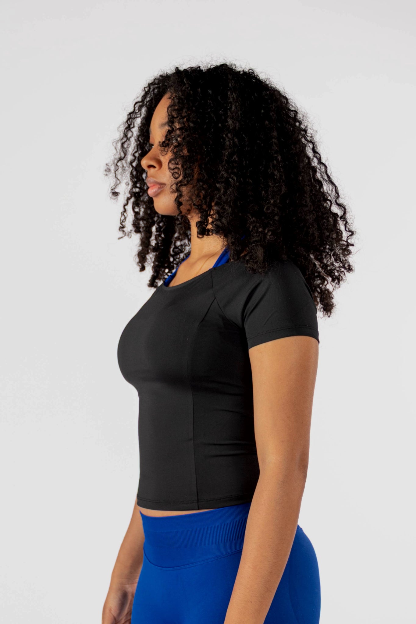 Model draagt de zwarte Nora Boothals Crop Top met Royal Blue Liberty Sculpting Legging - Dames gymkleding