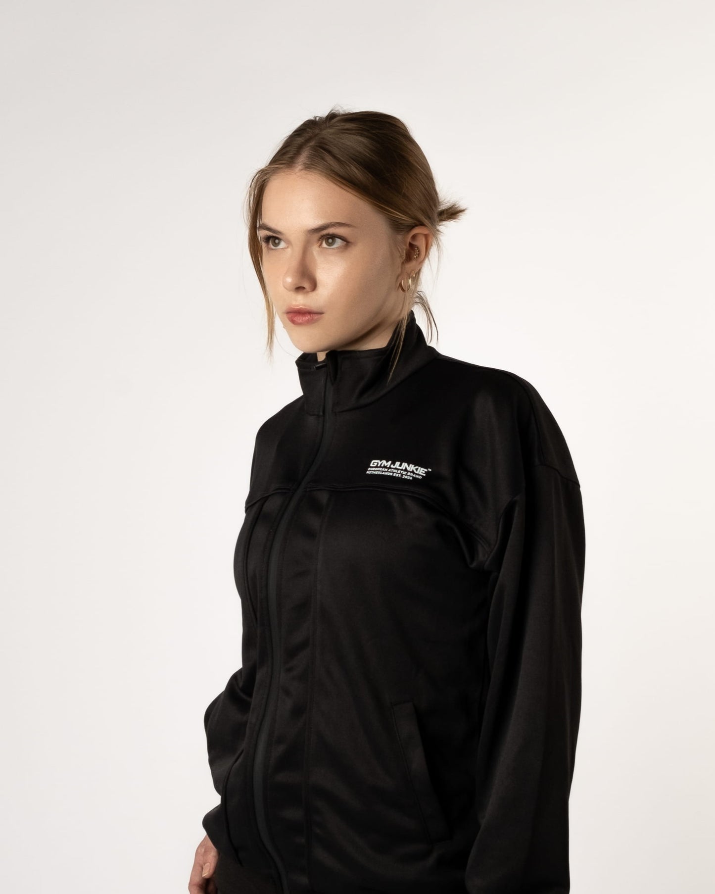 Zijaanzicht van vrouwelijke model in GJA Classic Trainingsjas, stoere en comfortabele trainingsjas voor dames die kracht en stijl combineren - Gym Jassen voor dames