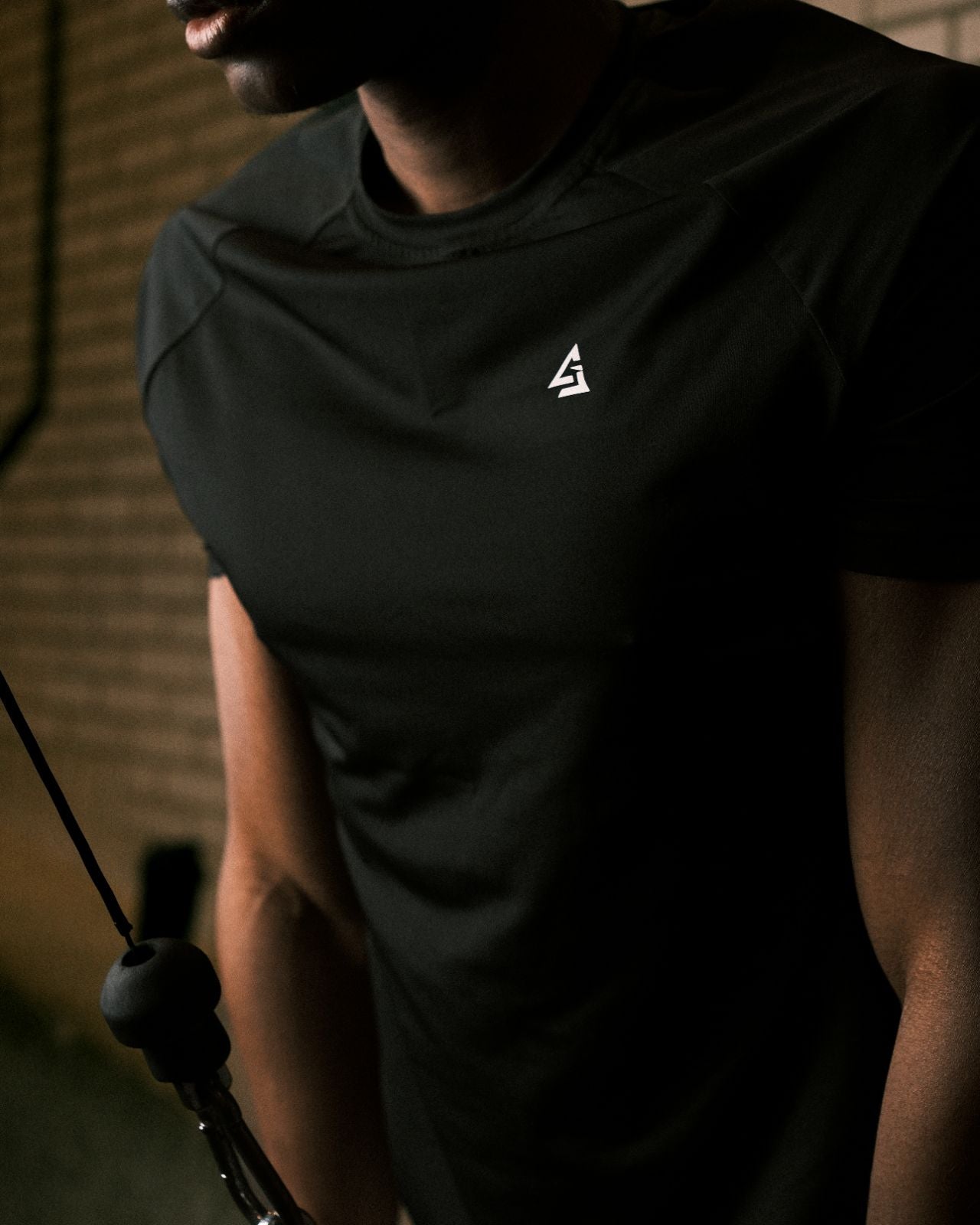 Close-up van mannelijke model in de Manga T-shirt van Gym Junkie tijdens training — strakke en duurzame gymwear voor heren met focus en ambitie  - Trainings t-shirt voor heren