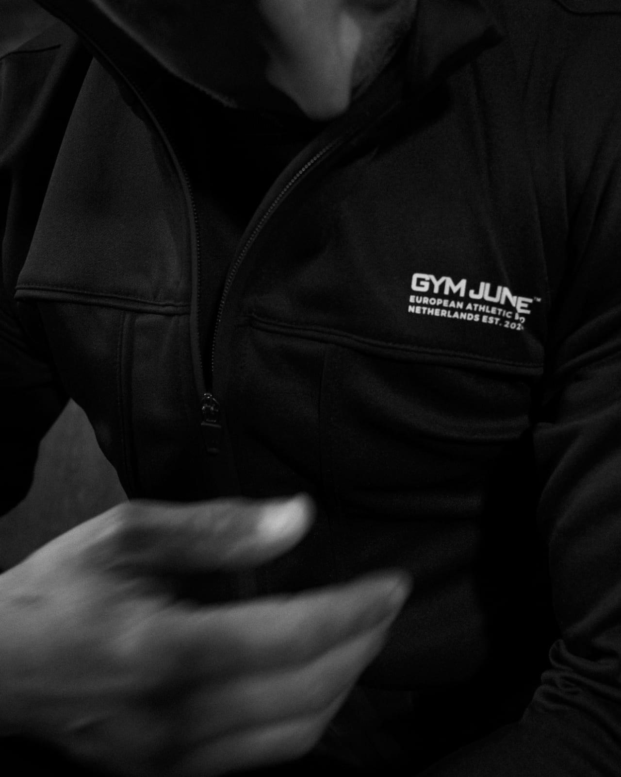 Close-up van Gym Junkie trainingsjas met zichtbaar logo EST 2024 – hoogwaardige sportkleding