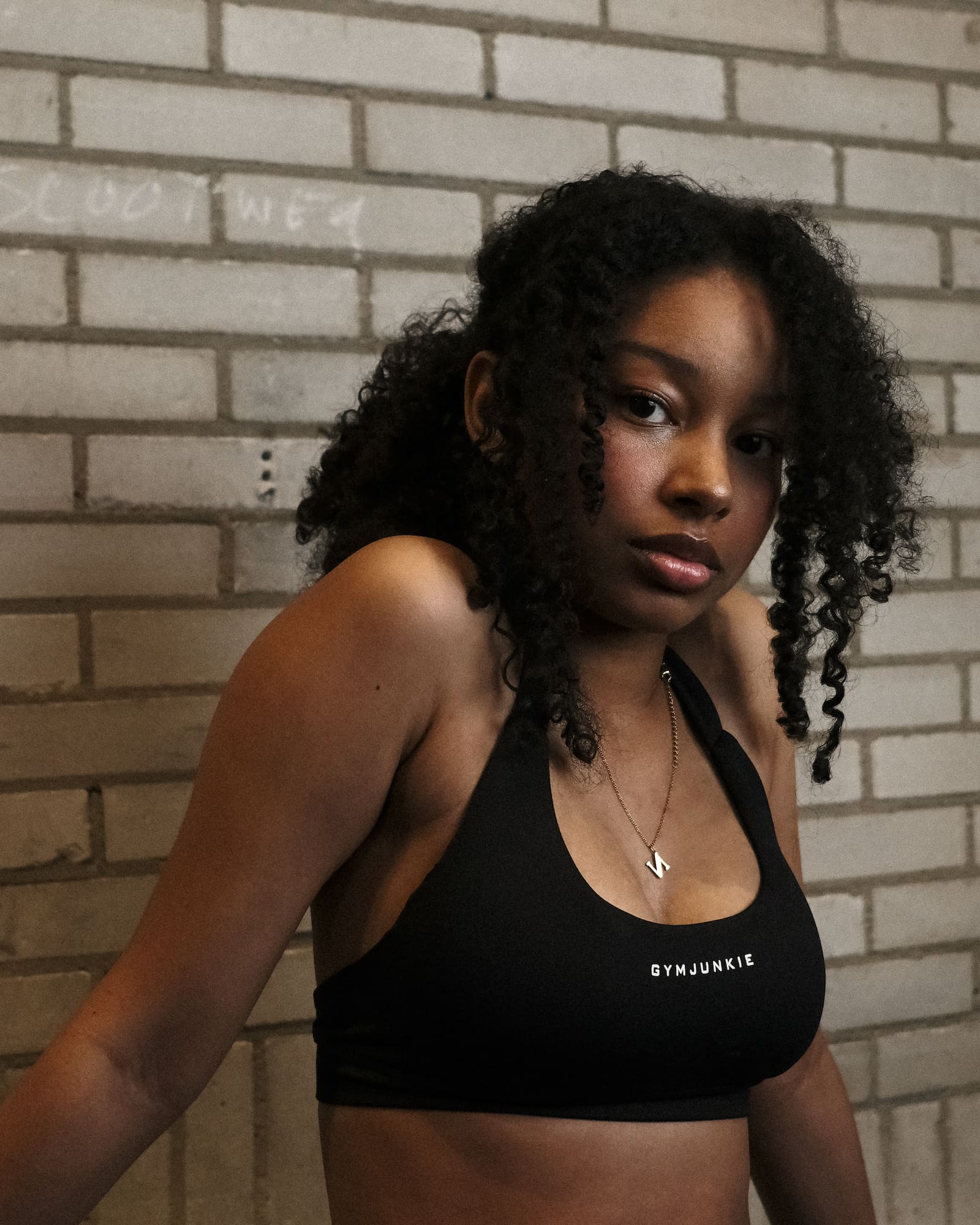 Vooraanzicht van model in zwarte Liberty sportbh, krachtige en comfortabele gymkleding voor jonge, zelfverzekerde vrouwen in Nederland - Gym Junkie Sportskleding voor dames