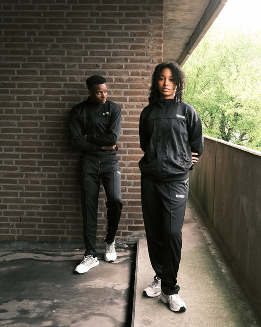 Man en vrouw dragen GJA trainingspak buiten, stijlvolle en krachtige sportoutfits voor jonge, gedurfde sporters die actief leven in Nederland