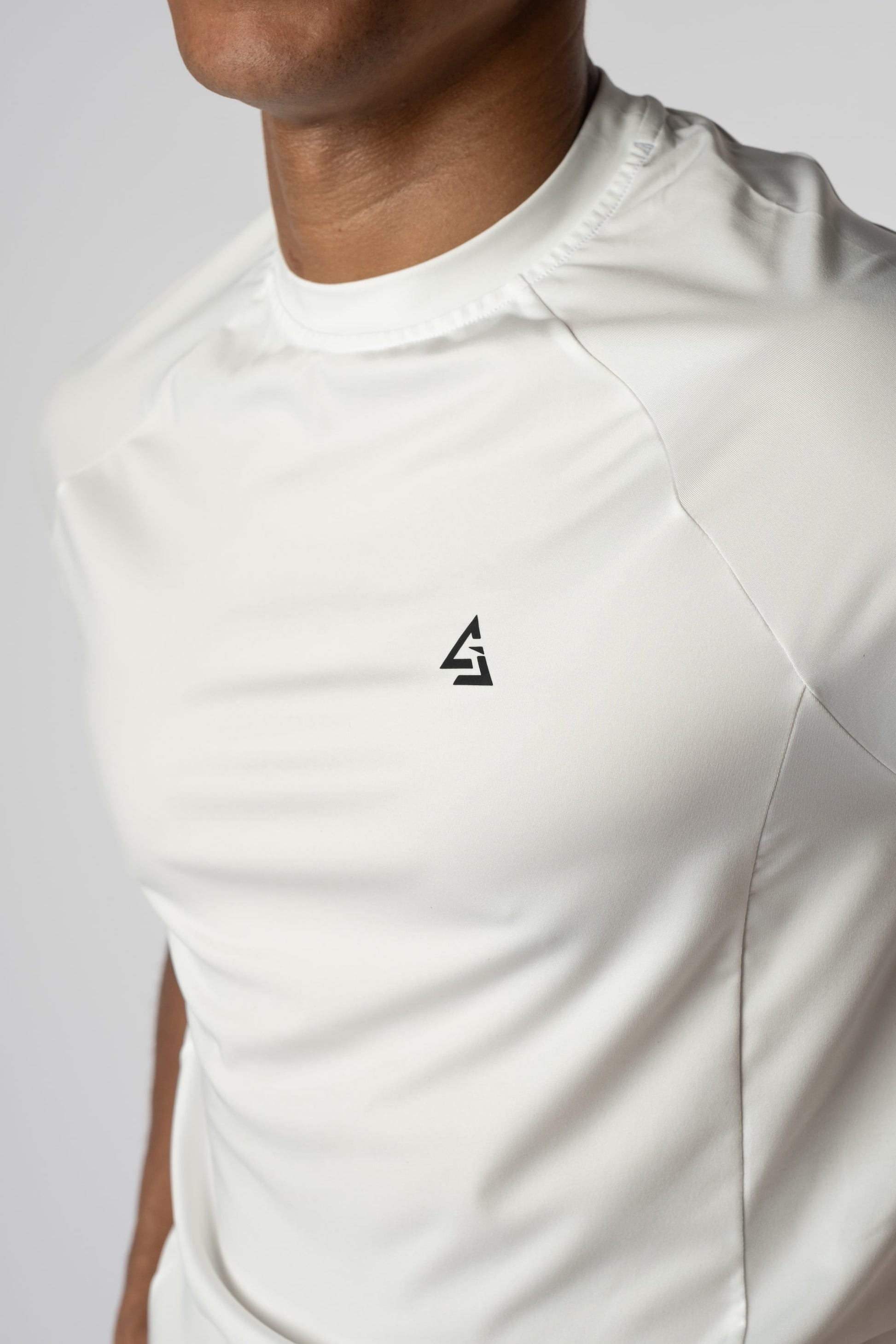 Close-up van het Gym Junkie-logo op een wit sportshirt voor actieve jongeren - Gymkleding voor heren