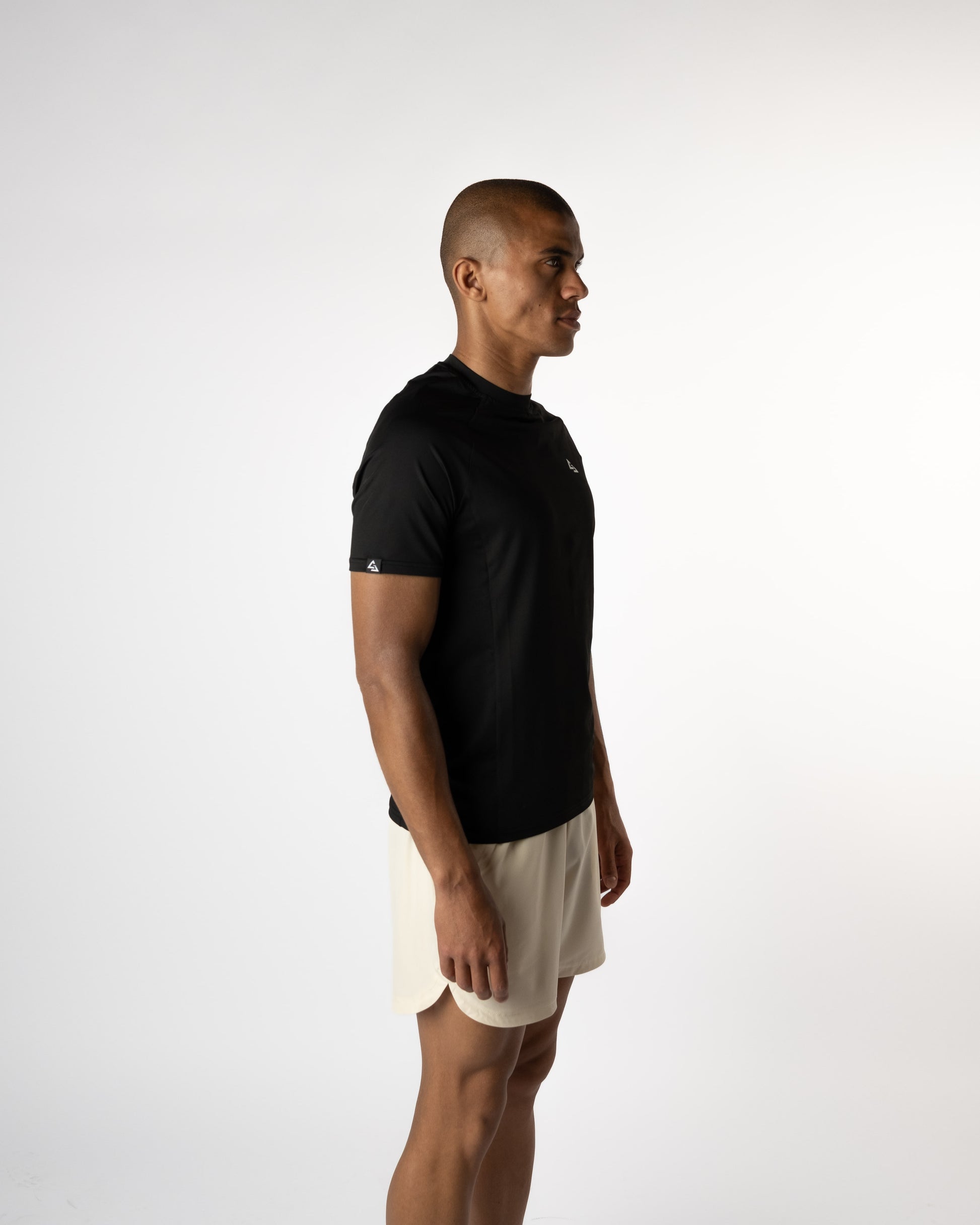 Zijaanzicht van model in de Manga Trainings T-shirt en Sand shorts van Gym Junkie, een krachtige gymoutfit voor heren die stijl en performance combineren