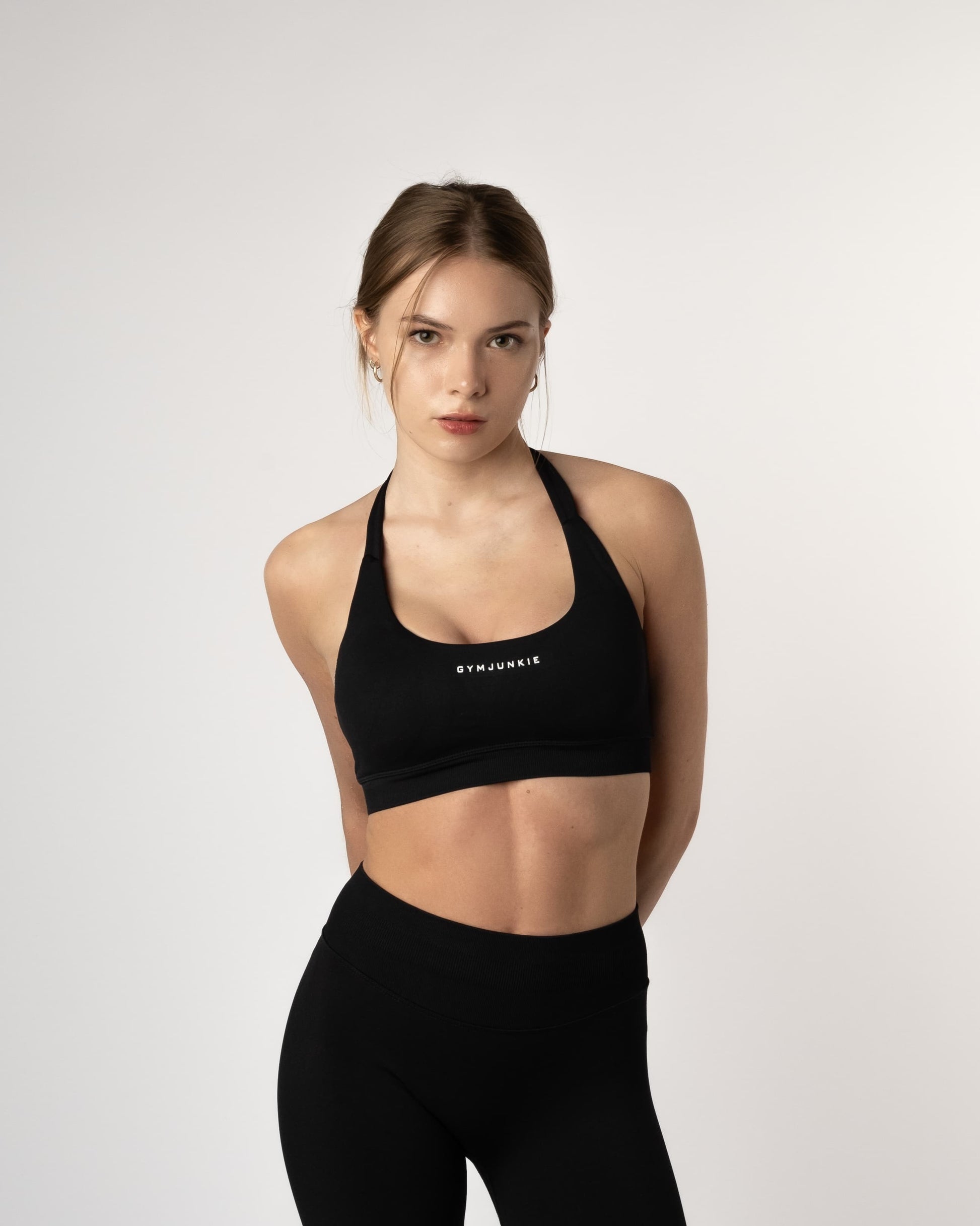 Model draagt zwarte Liberty naadloze sport bh en legging, stijlvolle en krachtige gymoutfit voor dames die zichzelf uitdagen in Nederland - Gym Junkie Sportwinkel